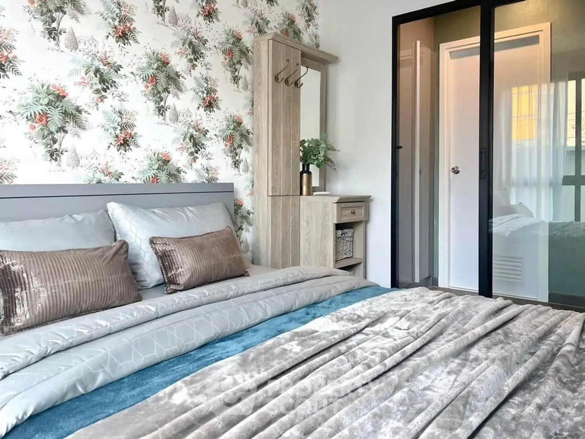 Stylish bedroom with floral wallpaper and cozy bedding in modern apartment