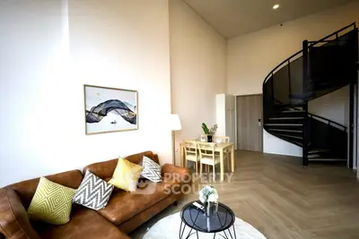 Modern living room with spiral staircase and stylish decor in a contemporary apartment.