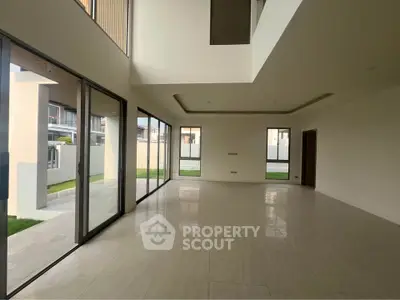 Spacious modern living room with large windows and elegant tile flooring
