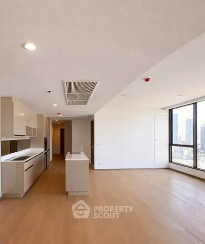 Spacious modern kitchen with open layout and city view, featuring sleek cabinetry and island.