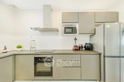 Modern kitchen with sleek cabinetry, built-in oven, and stainless steel appliances.