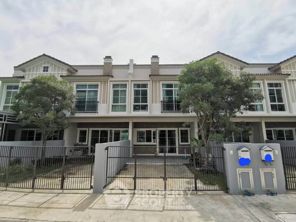 Modern townhouse exterior with gated entrance and lush greenery, perfect for family living.