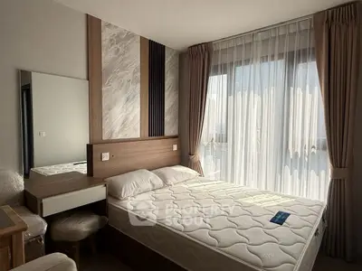 Modern bedroom with stylish decor and natural light from large window.