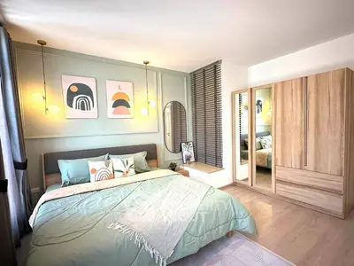 Modern bedroom with stylish decor, large wardrobe, and cozy bedding in a bright, inviting space.