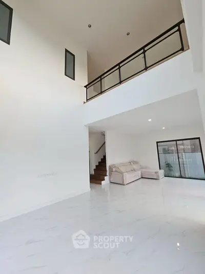 Spacious modern living room with high ceilings and elegant staircase