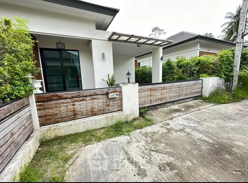 Charming single-story home with modern exterior and lush greenery, perfect for serene living.
