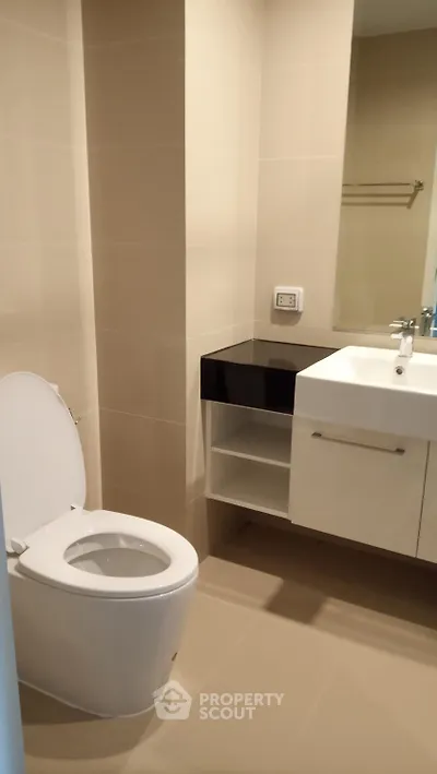 Modern bathroom with sleek fixtures and neutral tones, featuring a compact design for efficient space use.