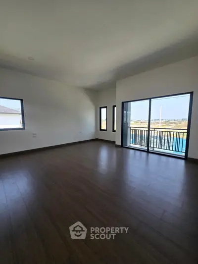 Spacious empty room with large windows and balcony access, perfect for customization.