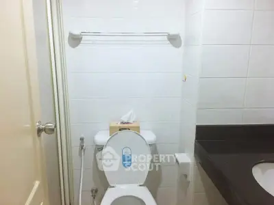 Compact bathroom with modern fixtures and tiled walls