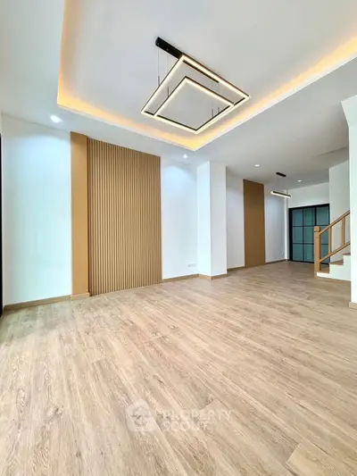 Spacious modern living room with elegant lighting and wooden flooring