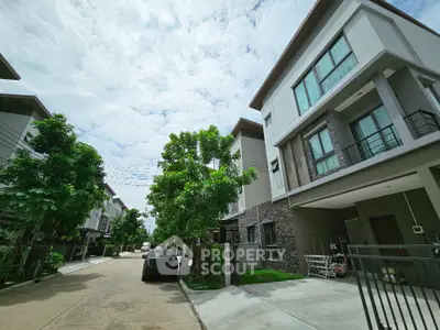 Modern townhouse complex with lush greenery and spacious driveways
