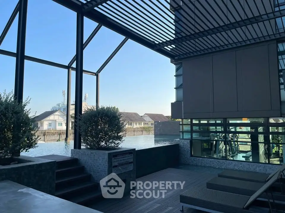 Modern waterfront building with gym and outdoor seating area offering stunning views.
