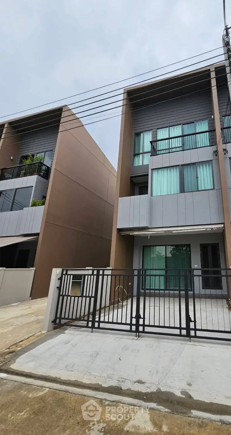 Modern townhouse exterior with sleek design and gated entrance
