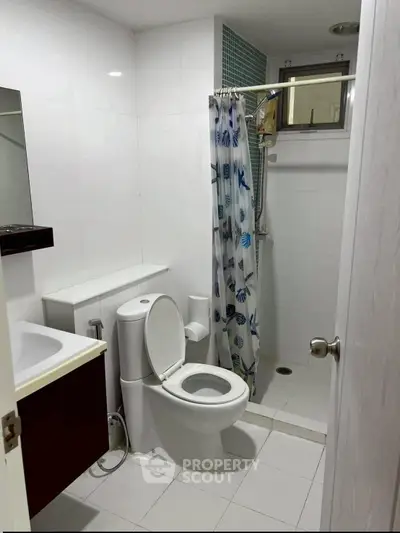 Modern bathroom with shower and toilet in sleek white design