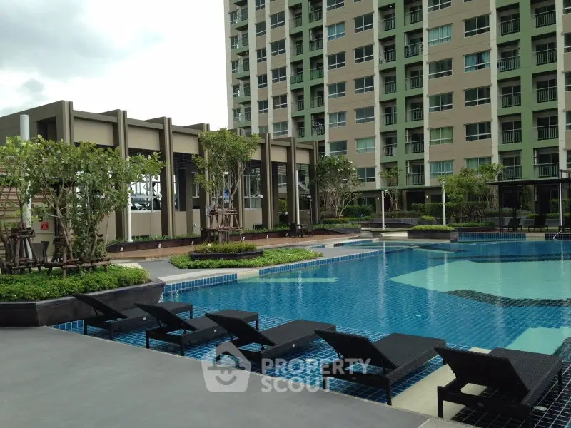 Luxurious condominium with modern pool and sun loungers, perfect for relaxation and leisure.