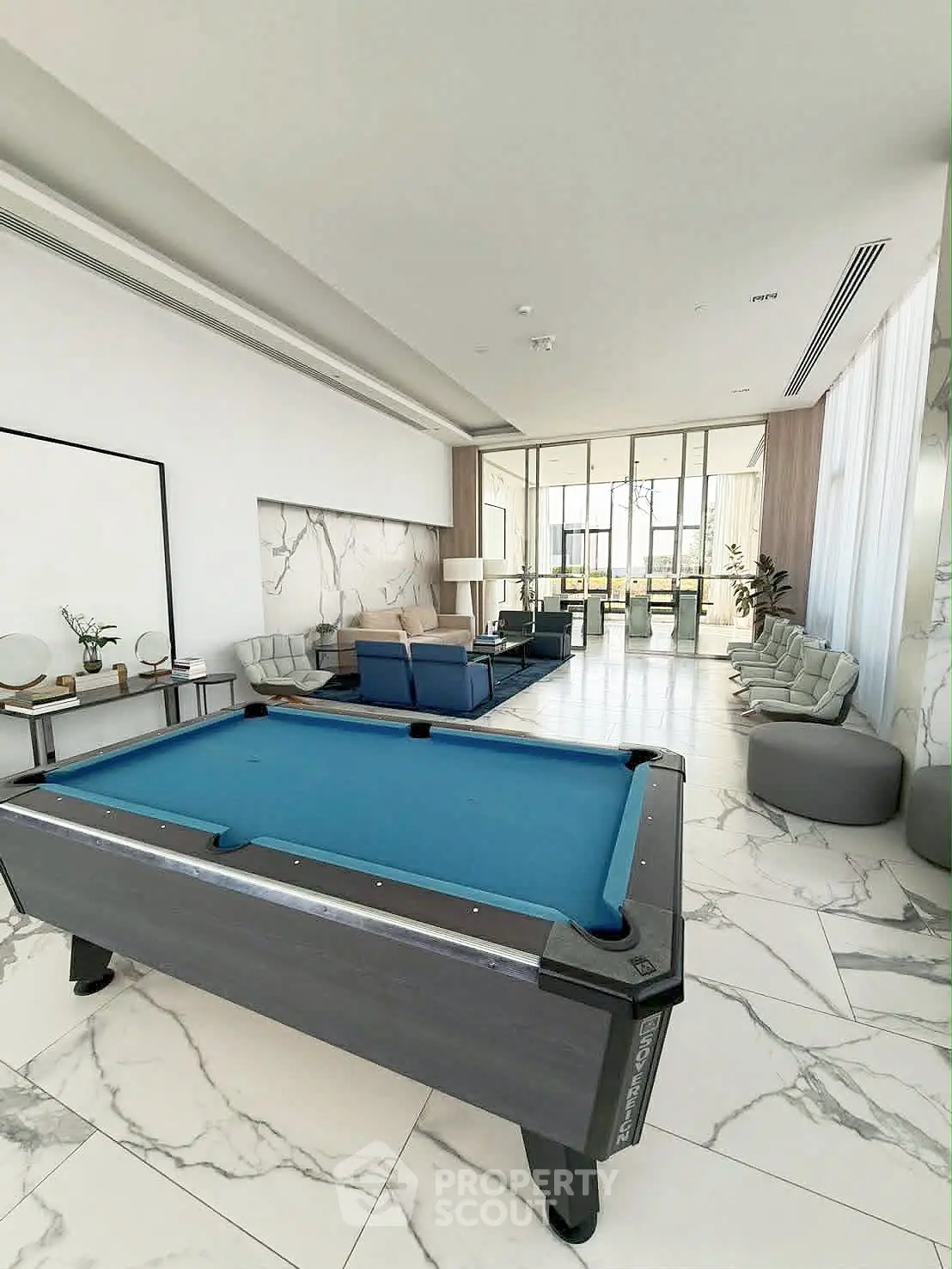 Luxurious common area with pool table and modern seating in elegant building.