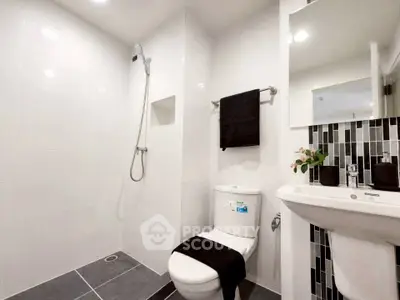 Modern bathroom with sleek design, featuring a shower, toilet, and stylish sink area.