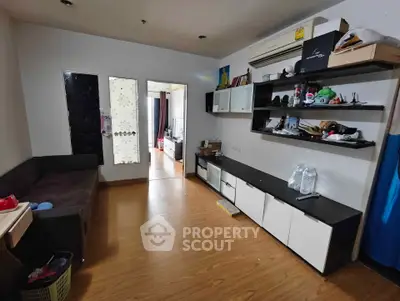 Spacious living room with modern shelving and wooden flooring, ideal for cozy family gatherings.