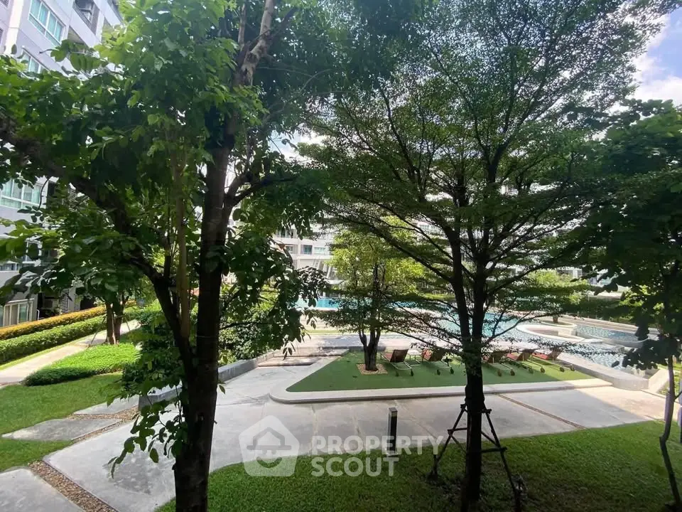 Luxurious residential pool area surrounded by lush greenery and modern architecture.