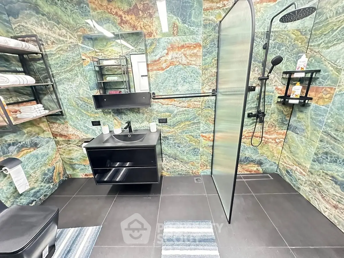 Luxurious modern bathroom with unique stone wall design and sleek black fixtures.