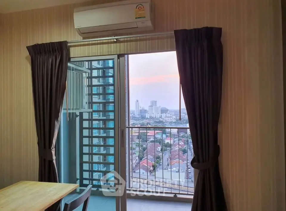Cozy apartment with balcony offering stunning cityscape views at sunset.