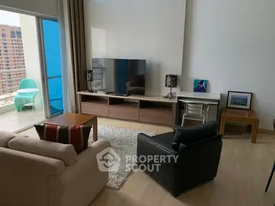 Modern living room with balcony access and stylish furniture in a high-rise apartment.