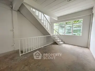 Spacious interior with staircase and large windows offering natural light