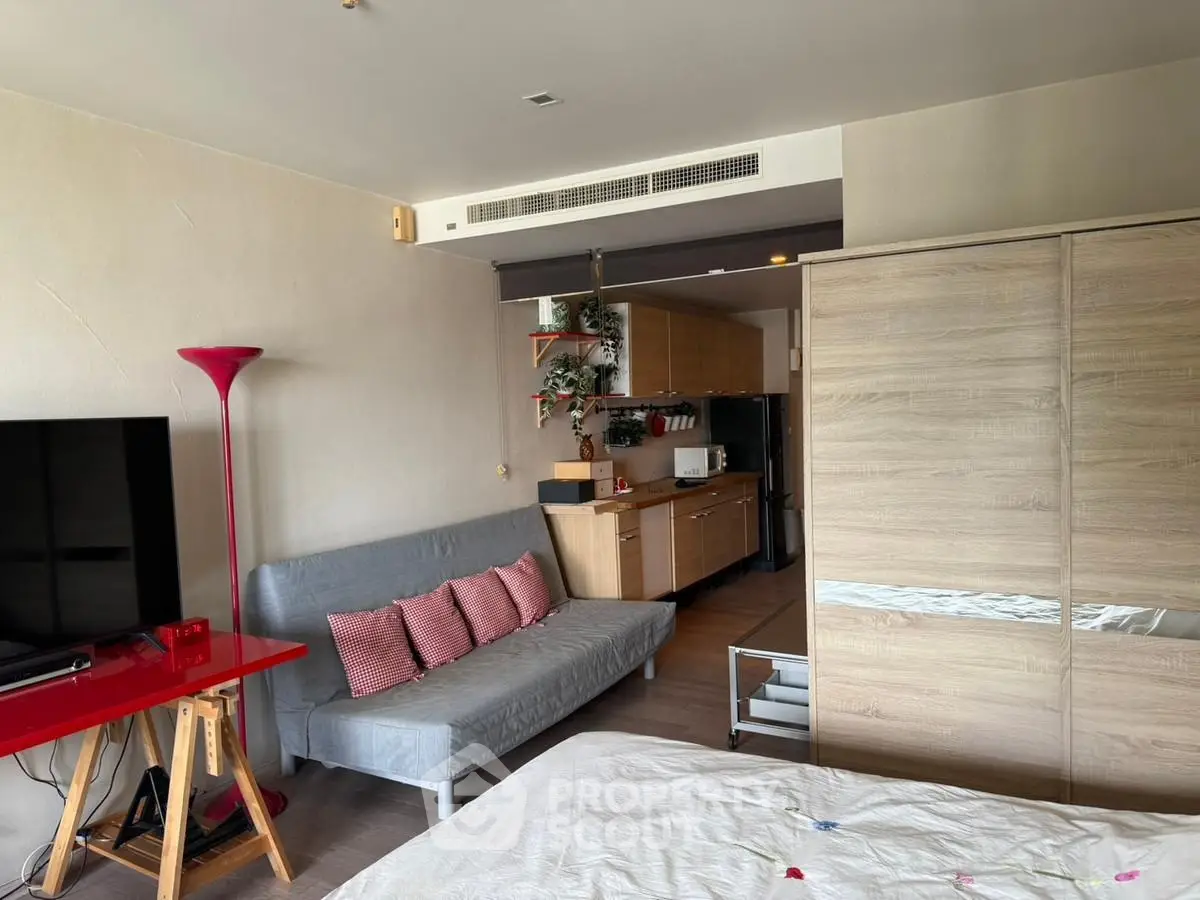 Modern studio apartment with cozy living area and compact kitchen