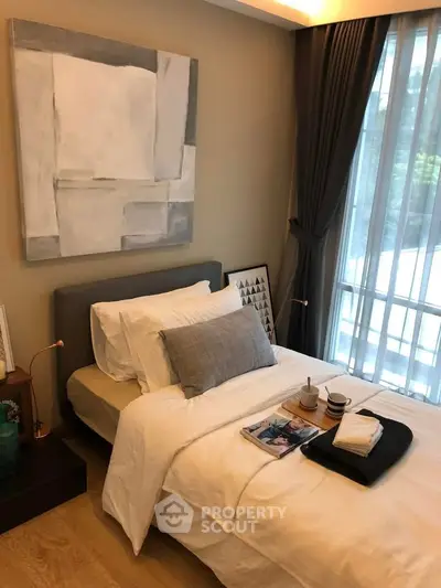 Cozy bedroom with modern decor and large window offering natural light