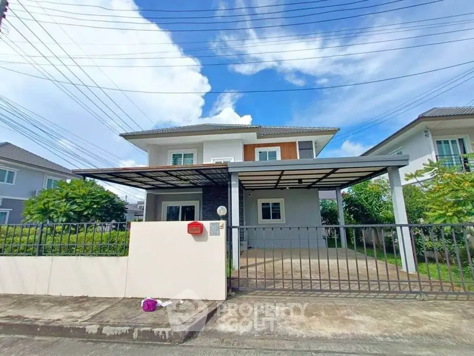 Modern two-story house with spacious driveway and gated entrance in suburban neighborhood.
