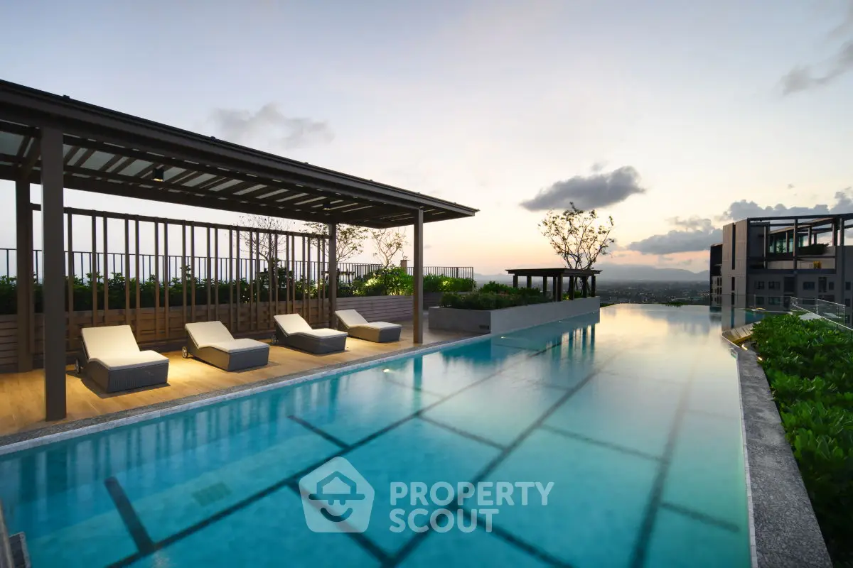 Luxurious rooftop pool with stunning sunset view and modern lounge chairs.