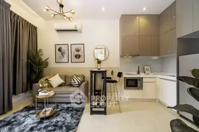 Modern living room with stylish decor and compact kitchen in open layout apartment.