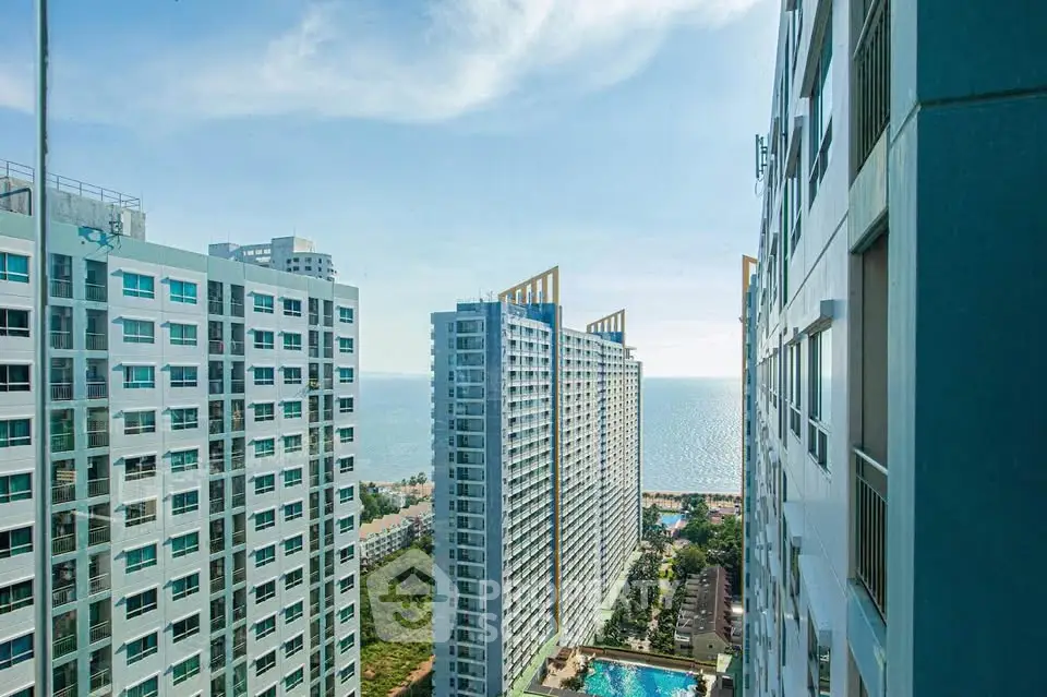 Stunning high-rise ocean view from modern apartment complex with pool and cityscape.