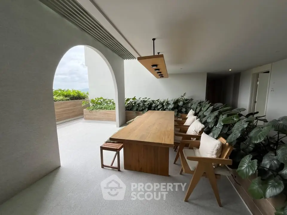Elegant rooftop terrace with modern wooden dining set and lush greenery