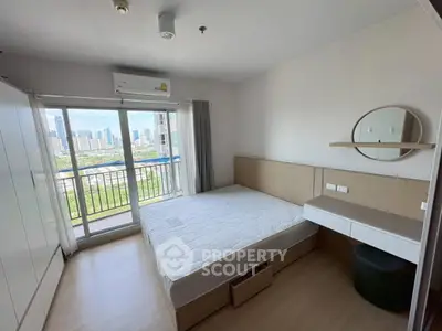 Modern bedroom with city view and balcony access in high-rise apartment