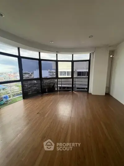 Spacious living room with large windows offering panoramic city views and abundant natural light.