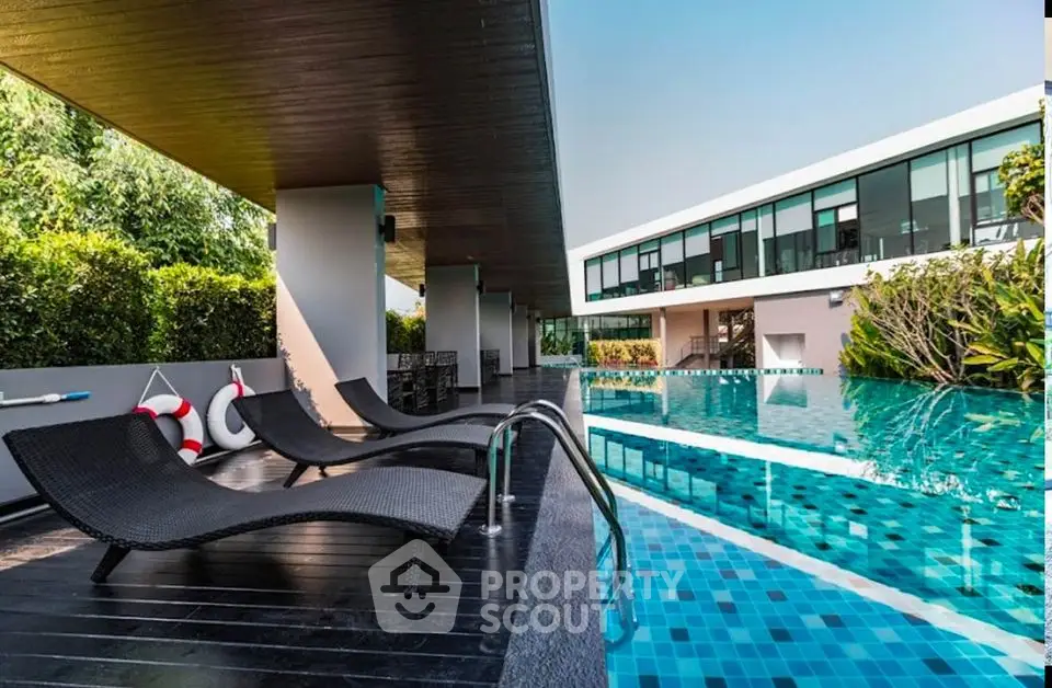 Luxurious modern poolside with sleek loungers and lush greenery, perfect for relaxation and leisure.