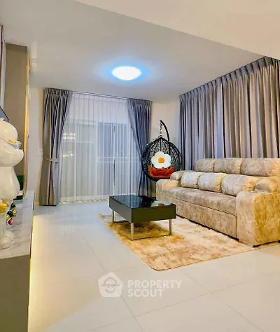 Elegant living room with plush sofa, modern decor, and cozy hanging chair for ultimate relaxation.