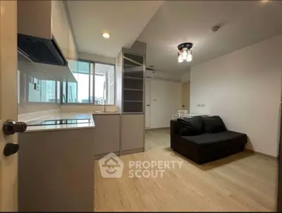 Modern open-layout living room with sleek kitchen and cozy seating area