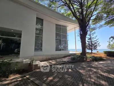 Modern building exterior with large windows and lush greenery, offering serene views and natural light.