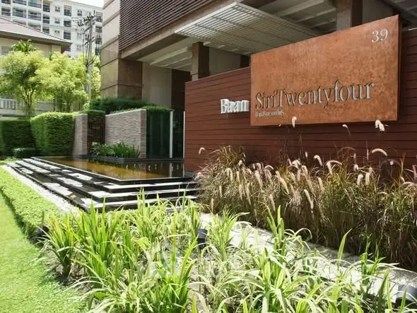 Luxurious modern building entrance with lush landscaping at Baan Siri Twentyfour.