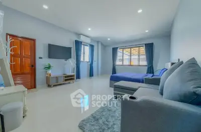 Spacious modern living room with sleek furniture and large windows offering natural light.