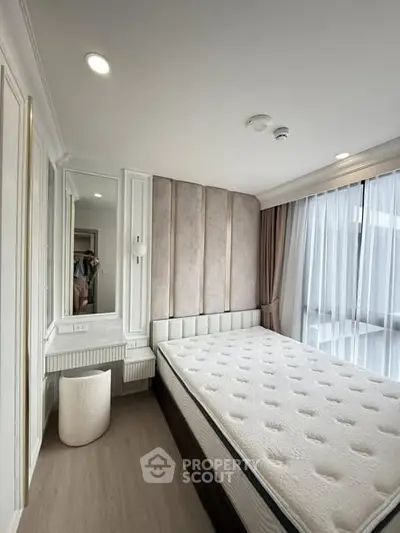 Luxurious bedroom with elegant decor and large window for natural light.