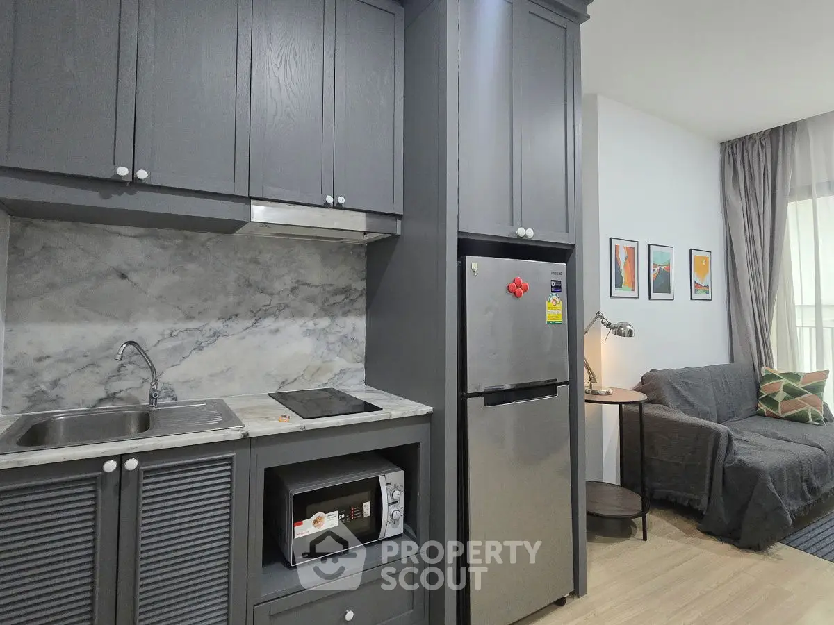Modern kitchen with sleek cabinets and cozy living area in stylish apartment