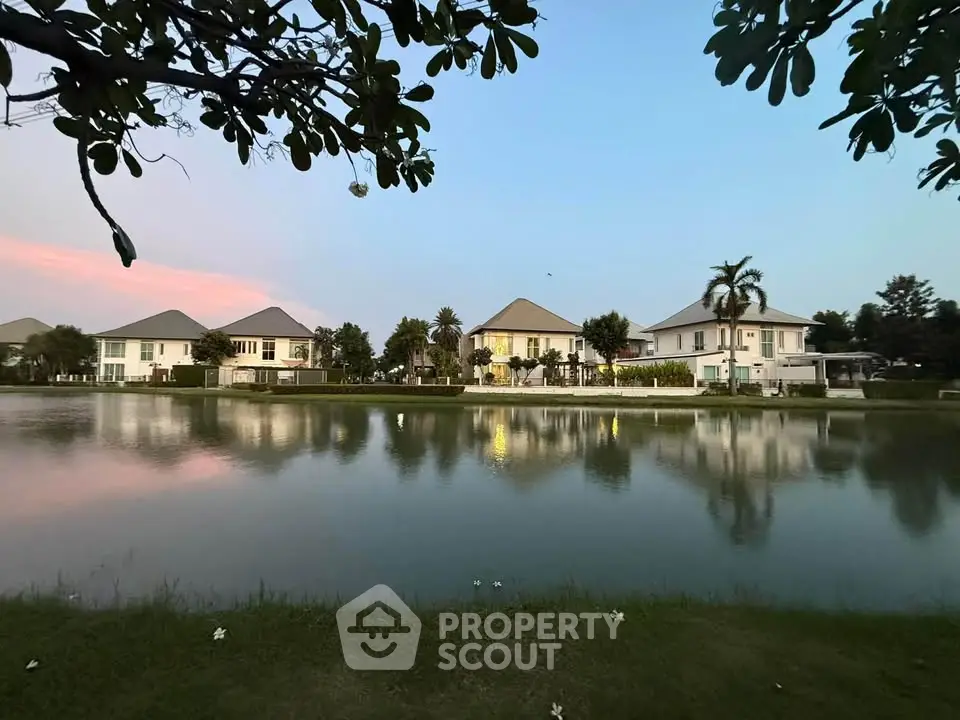 Charming lakeside view of elegant homes with serene surroundings and lush greenery, perfect for tranquil living.