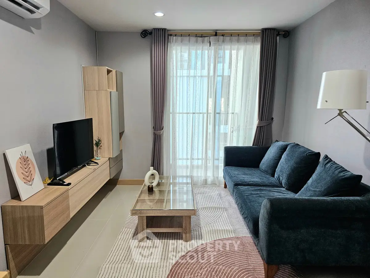 Modern living room with stylish furniture and natural light from large window.