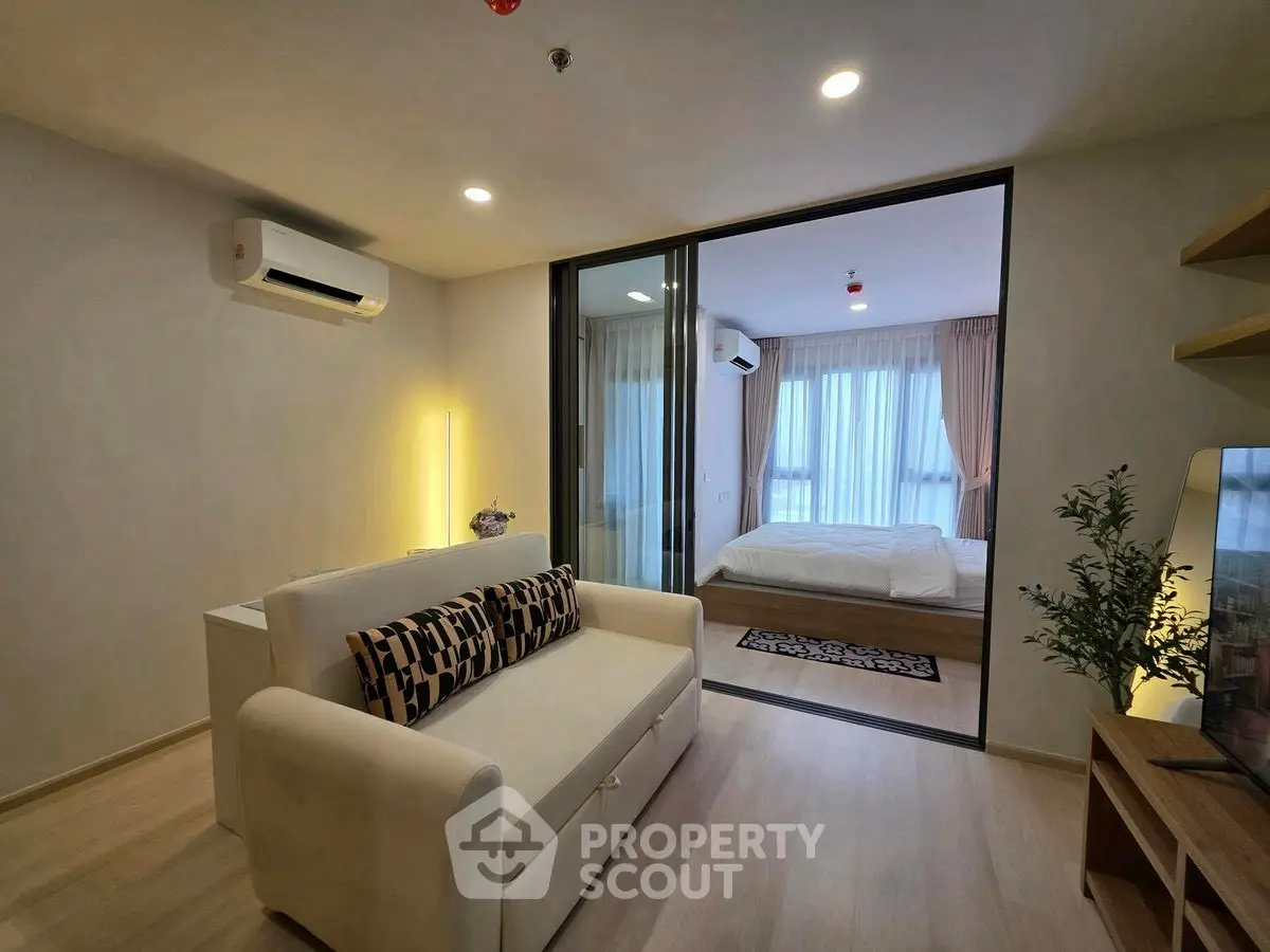 Modern living room with cozy sofa and stylish bedroom view