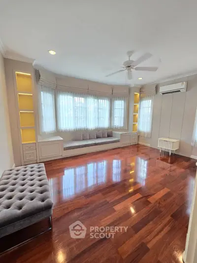 Spacious living room with polished wooden floors and large windows