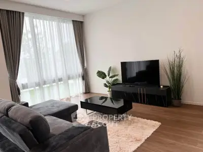Modern living room with sleek furniture and large window, perfect for relaxation.