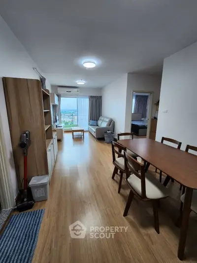 Spacious modern living room with dining area and balcony view